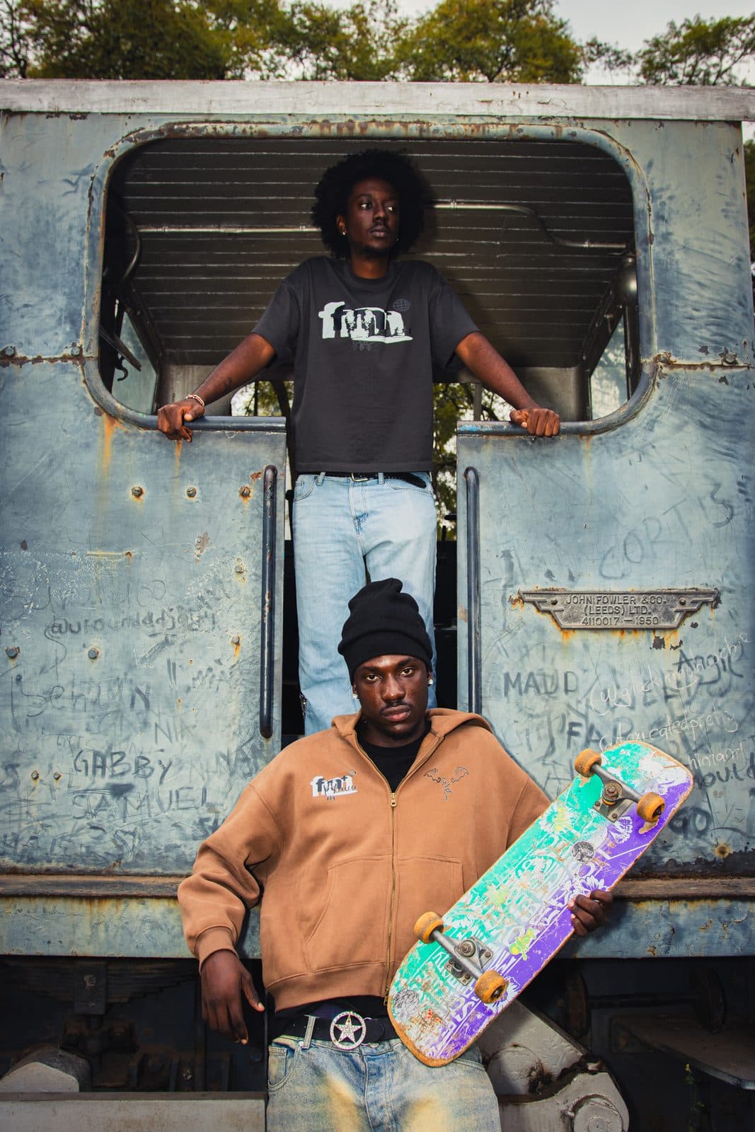 Earth-brown zip hoodie worn in the yard, board under one arm